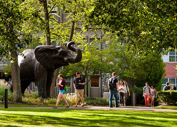Students walking on campus by the Jumbo Statue